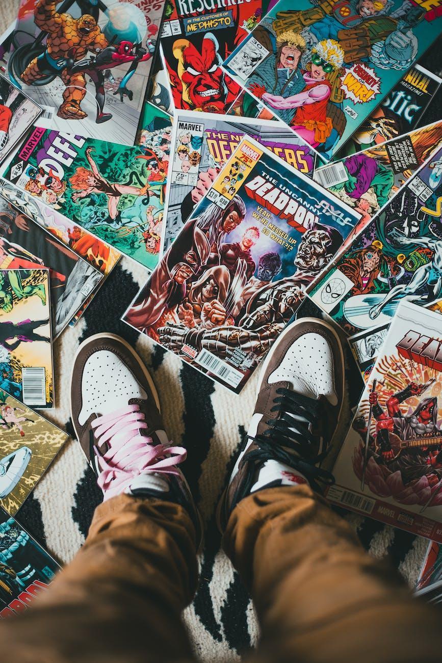 person standing on pile of comics books